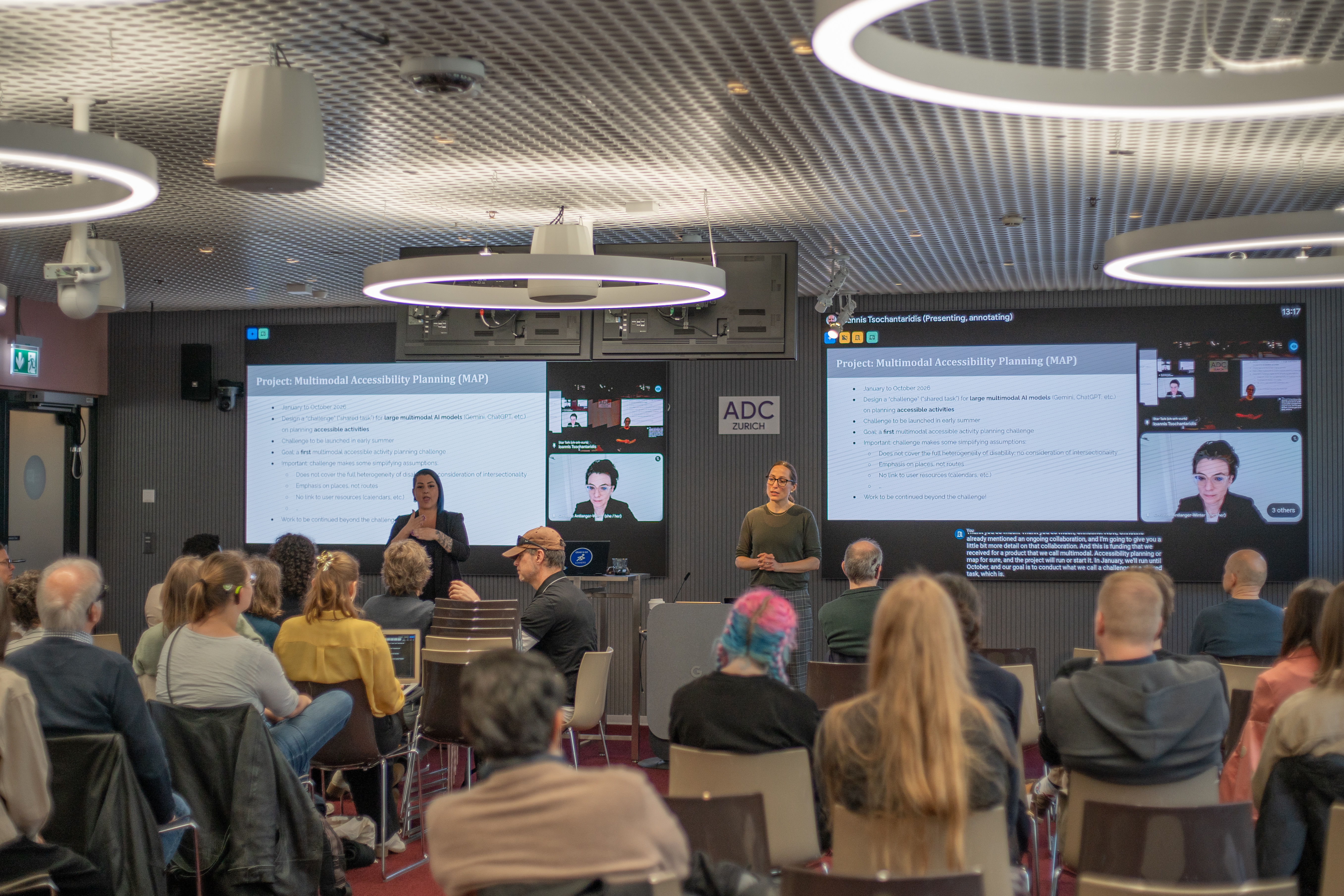 Sarah Ebling presenting in front of the workshop participants. Her contribution is interpreted into international sign and tactile signing.